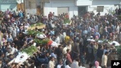 Anti-government protesters carry the coffins of Sunni Muslim villagers killed on Wednesday, in Hula near Homs, November 2, 2011.