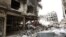 FILE - Rubble and heavy damage remain on a deserted street during a government escorted visit to Yarmouk refugee camp in Damascus, Syria, April 9, 2015. The United Nations brokered a deal to relocate some IS fighters and their families.