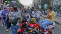 Un groupe de jeunes hommes égyptiens lançant des commentaires sexistes contre des filles dans la rue au Caire, en Égypte, le 15 juin 2018 (Hamada Elrasam/VOA)