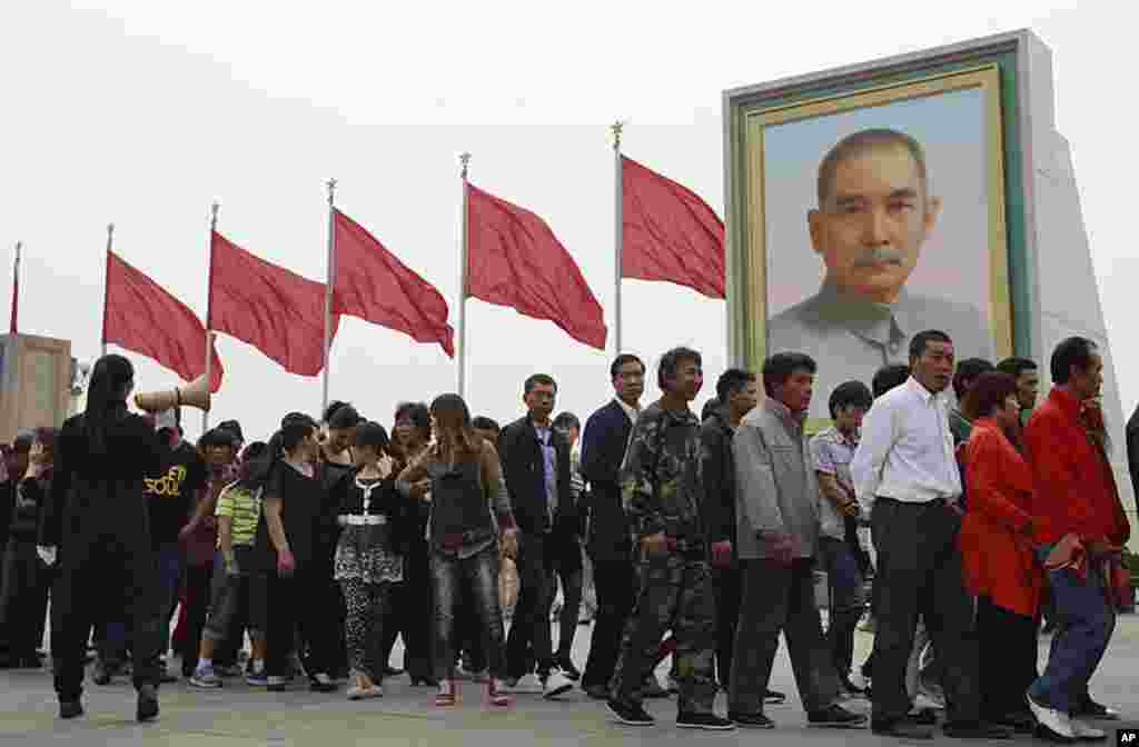 Hàng ngàn du khách đổ xô đến Quảng trường Thiên An Môn để vui hưởng Ngày Lễ Lao động, một ngày lễ công cộng. Mọi người đứng sắp hàng trước ảnh Tôn Dật Tiên để viếng xác ướp của cố lãnh tụ Trung Quốc Mao Trạch Đông, tại lăng mộ ông này ở Bắc Kinh, Trung Qu