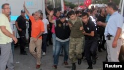 FILE - Soldiers suspected of being involved in the coup attempt are escorted by policemen as they arrive at a courthouse in the resort town of Marmaris, Turkey, July 17, 2016. Ankara is seeking the extradition of several soldiers who fled to Greece.