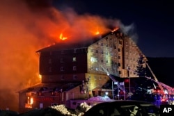 Petugas pemadam kebakaran berupaya memadamkan api di sebuah hotel di resor ski Kartalkaya di provinsi Bolu, di barat laut Turki, Selasa, 21 Januari 2025. (IHA via AP)