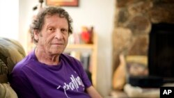 In this May 7, 2009, file photo, author, comedian and co-founder of the Yippie party as well as stand-up satirist, Paul Krassner, 77, poses for a photo at his home in Desert Hot Springs, Calif. 