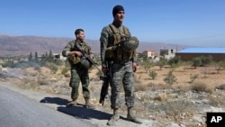 FILE - Lebanese army soldiers stand guard at an entrance to Arsal, a predominantly Sunni Muslim town near the Syrian border in eastern Lebanon, Aug. 4, 2014.