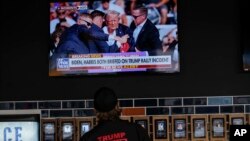 Una persona mira noticias en un bar local cerca del Fiserv Forum antes de la Convención Nacional Republicana de 2024, el 13 de julio de 2024, en Milwaukee.