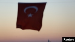 FILE - The Turkish national flag hangs in the foreground as drilling vessel Fatih is seen off the Mediterranean resort city of Antalya, Turkey