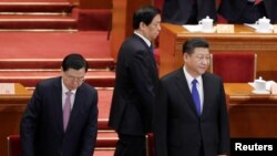 Anggota Komite Tetap Politburo (Politburo Standing Committee) Li Zhanshu (tengah) berjalan melewati Presiden China Xi Jinping (kanan) dan Ketua Komite Tetap Kongres Rakyat Nasional (NPC) pada saat mereka tiba untuk sesi pembukaan Sidang Kongres Rakyat Nasional di Aula Besar Rakyat di Beijing, China, 3 Maret 2018.