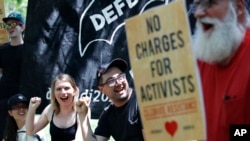 Chelsea Manning, left, cheers with Dylan Petrohilos, right, of Washington, as they attend a rally in support of the J20 defendants in Washington, May 11, 2018.