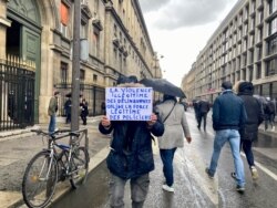 A supporter of the May 19, 2021, police protest holds a sign in Paris. Translated, it reads, "Illegitimate violence of delinquents forces the legitimate force of police." (Lisa Bryant/VOA)