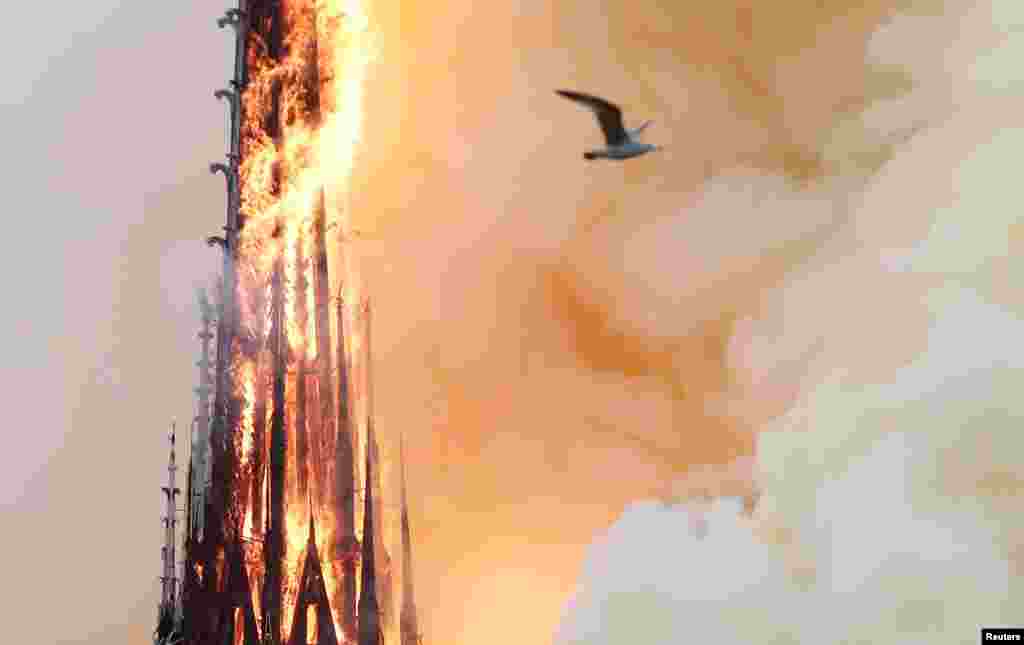 Smoke billows as fire engulfs the spire of Notre Dame Cathedral in Paris, France, April 15, 2019. 