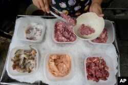 In Bangkok, rising costs for pork, vegetables and oil have forced Warunee Deejai, a street-food vendor, to raise prices, cut staff and work longer hours. (AP Photo/Sakchai Lalit)