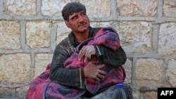 FILE - A Syrian man weeps as he cradles the body of his daughter who was killed following reported shelling in the town of Khan Sheikhun in the southern countryside of the rebel-held Idlib province, Feb. 26, 2019. 