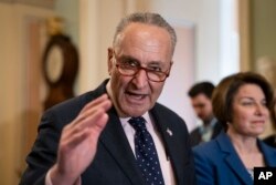 FILE - Senate Minority Leader Chuck Schumer, D-N.Y., joined at right by Sen. Amy Klobuchar, D-Minn., speaks to reporters at the Capitol in Washington, April 9, 2019.