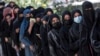 FILE - Female Afghan students stand in a queue after they arrive for entrance exams at Kabul University in Kabul on Oct. 13, 2022. After the hardline Taliban regained power in Afghanistan, they banned girls’ education past the sixth grade.