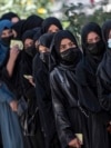 FILE - Female Afghan students stand in a queue after they arrive for entrance exams at Kabul University in Kabul on Oct. 13, 2022. After the hardline Taliban regained power in Afghanistan, they banned girls’ education past the sixth grade.