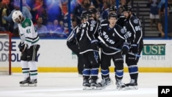 Tampa Bay Lightning's Ondrej Palat (18), of Czech Republic, is congratulated on his goal by teammates, including Tyler Johnson (9) and Nikita Kucherov (86), of Russia, as Dallas Stars' Gemel Smith reacts during the third period of an NHL hockey game, April 2, 2017.