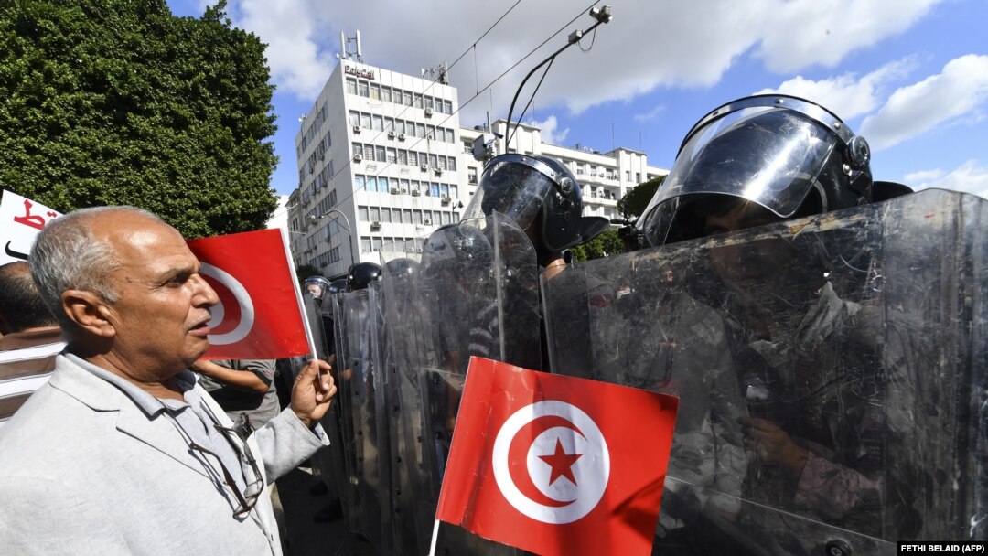 Umwe mu bayoboke b'ishyaka Ennahdha riyobowe na Noureddine Bhiri wigeze kuba ministiri w’ubutabera muri Tuniziya, mu myigaragambyo yo kwamagana ubutegetsi bwa Perezida Kais Saied 