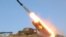 In this undated photo released by the Korean Central News Agency (KCNA) and distributed March 14, 2013, by the Korea News Service, a rocket launcher is fired during a live drill by the Jangjae Islet Defense Detachment and the Mu Islet Hero Defense Detachment.