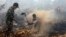 Warga dan tentara berupaya memadamkan kebakaran di sebuah lahan di Rimbo Panjang, Riau, September 2015. 