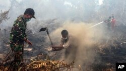 Warga desa dan petugas militer berupaya memadamkan kebakaran hutan di Rimbo Panjang, provinsi Riau, 6 September 2015 (Foto: dok).