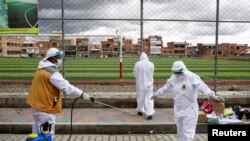 Trabajadores de la salud desinfectan a un colega en El Alto, Bolivia, en medio de un repunte de la pandemia de coronavirus en el país, el 16 de enero de 2021.