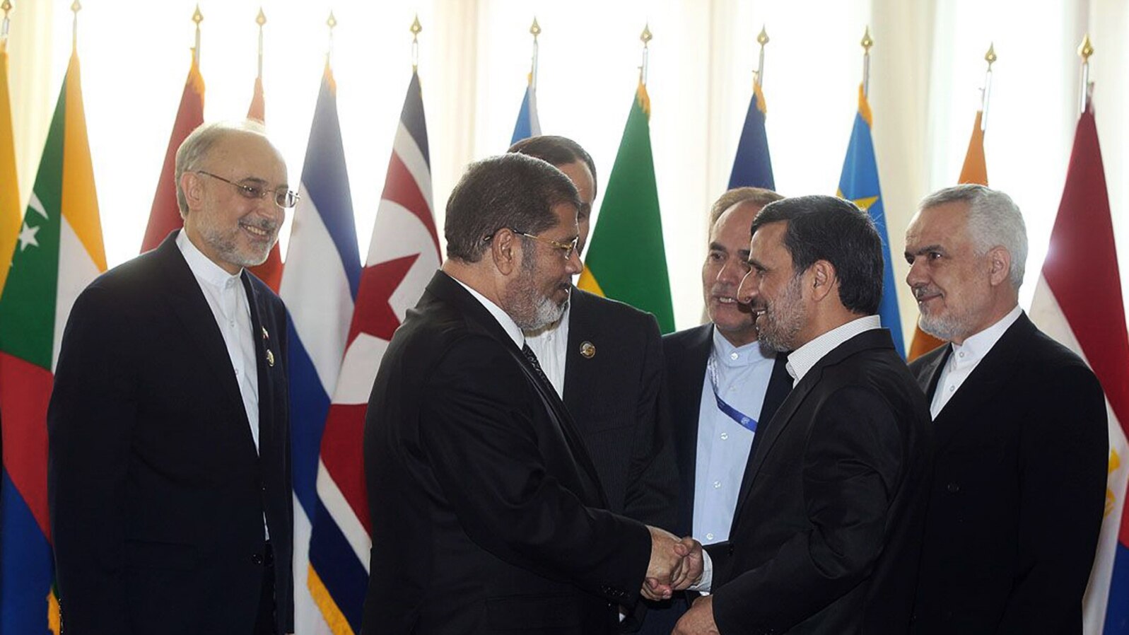 Iranian President Mahmoud Ahmadinejad welcomes Egyptian President Mohammed Morsi during the opening session of the Non-aligned Movement summit, in Tehran, August 30, 2012.