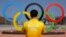 FILE - A volunteer photographs a set of Olympic Rings at Olympic Park in Rio de Janeiro, Brazil, July 29, 2016.