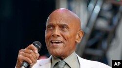FILE: FILE - In this July 20, 2014 file photo, singer and activist Harry Belafonte speaks during a memorial tribute concert for folk icon Pete Seeger at Lincoln Center's Damrosch Park in New York.