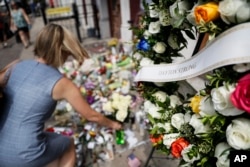 Mourners bring flowers to a makeshift memorial, Aug. 6, 2019, for the slain and injured in the Oregon District after a mass shooting that occurred Aug. 4, 2019, in Dayton, Ohio.