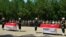 Turkish soldiers, army officers and officials stand at attention next to the coffins of soldiers Mehmet Kocak and Ismail Yavuz, during a ceremony in Diyarbakir, Turkey, Sunday, July 26, 2015.
