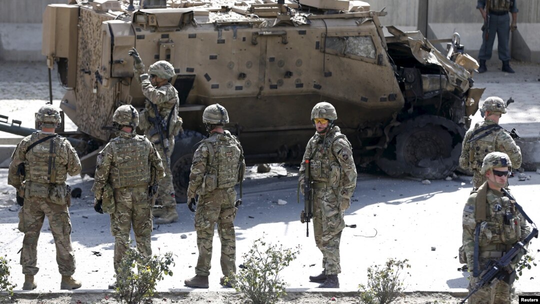 Tentara NATO berdiri di dekat lokasi serangan bunuh diri yang merusak sebuah kendaraan NATO di Kabul, Afghanistan (foto: dok). NATO mengukuhkan serangan bunuh diri terhadap konvoinya di Afghanistan selatan, hari Rabu (2/8). 