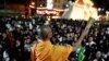 A buddhist monk sprinkles holy water as people pray for victims who died in a mass shooting involving a disgruntled Thai soldier on a shooting rampage, in Nakhon Ratchasima, Thailand, Feb. 9, 2020.