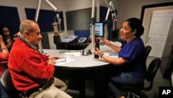 In this Aug. 23, 2019 photo, Julio Cesar Camacho, a Venezuelan journalist and one of the most popular Spanish-language radio hosts, speaks with Democratic Florida Rep. Cindy Polo, during his show "Democracia al Dia," in Doral, Florida. 