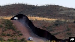 Agentes de la patrulla fronteriza de EE.UU. resguardan la valla que divide la frontera con México cerca de Naco, Arizona.