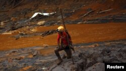 A rescue worker searches for victims at Bento Rodrigues district that was covered with mud after a dam owned by Vale SA and BHP Billiton Ltd. burst, in Mariana, Brazil, Nov. 8, 2015. 