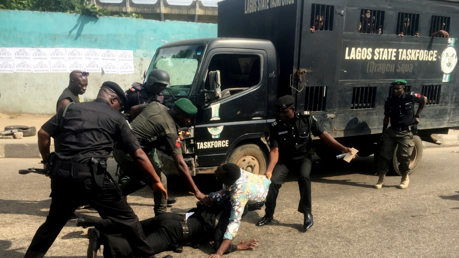 FILE - Police officers pull a journalist during an anti-government protest in Lagos, August 5, 2019. 