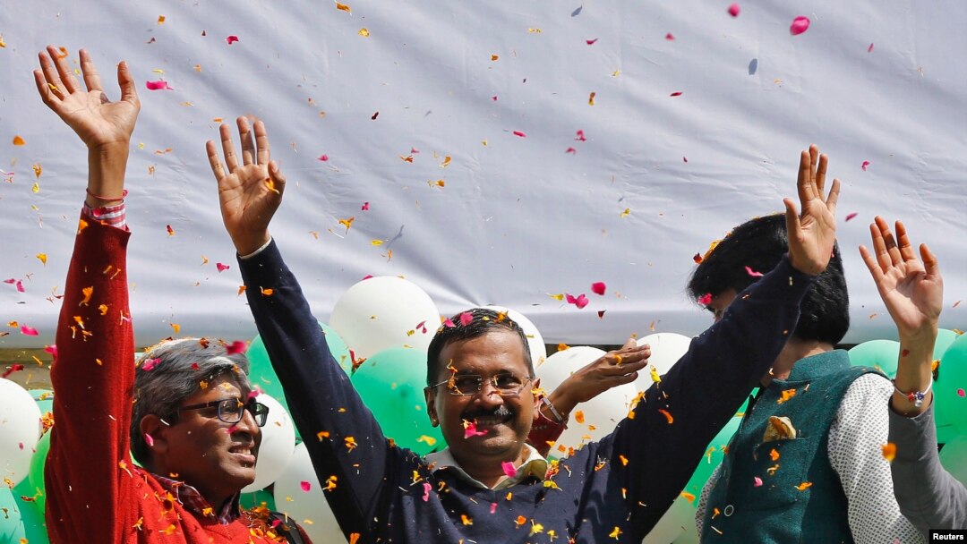 Ketua Partai Aam Aadmi (AAP) dan kandidat Gubernur New Delhi, Arvind Kejriwal (tengah) memberikan salam kepada para pendukungnya seusai memenangkan pemilu (10/2). 