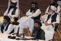 FILE - Taliban co-founder Abdul Ghani Baradar, bottom right, speaks during peace talks between the Afghan government and the Taliban in Doha, Qatar, Sept. 12, 2020. Baradar led a Taliban contingent in talks with the U.S. March 5, 2021, in Doha.