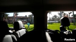 A United States Secret Service agent is seen from a press van at President Donald Trump's Mar-a-Lago estate in Palm Beach, Florida.