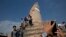 FILE - Locals take snapshots with their cell phones at the historic Dharahara Tower, a city landmark, that was damaged in Saturday’s earthquake in Kathmandu, Nepal, April 27, 2015. 