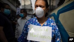 Una enfermera lleva el mensaje que reza "basta de humillarnos" mientras los trabajadores de la salud se unen a una manifestación de maestros por mejores salarios Caracas, el 21 de octubre de 2020.