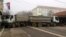 A man passes by a barricade made of trucks loaded with stones that was erected during the night on a street in northern, Serb-dominated part of ethnically divided town of Mitrovica, Kosovo, Dec. 27, 2022.