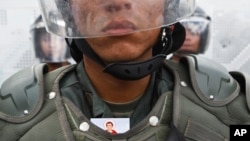 ARCHIVO - Un militar venezolano no identificado hace guardia junto a otros uniformados durante una protesta contra el gobierno de Nicolás Maduro en Caracas, el 16 de marzo de 2014. Uno de los jefes militares de la época acaba de ser detenido en EEUU.