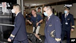 FILE - Crew from China Eastern Airlines leave the airport wearing face masks after arriving in Sydney, Jan. 23, 2020, on a flight from Wuhan, China. 