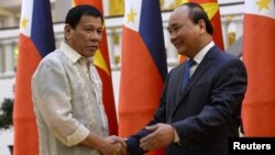 Philippines' President Rodrigo Duterte, left, greets Vietnamese Prime Minister Nguyen Xuan Phuc as they meet at Phuc's Cabinet Office in Hanoi, Vietnam, Sept. 29, 2016. Both nations are attempting to modernize their militaries.