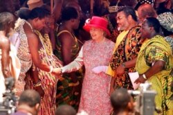 FILE - Britain's Queen Elizabeth II, flanked to the right by Ghanaian President Jerry Rawlings, shakes hands with one of over a dozen Ghanaian tribal chiefs lined up to greet her, at an outdoor ceremony in Accra, Nov. 8, 1999.