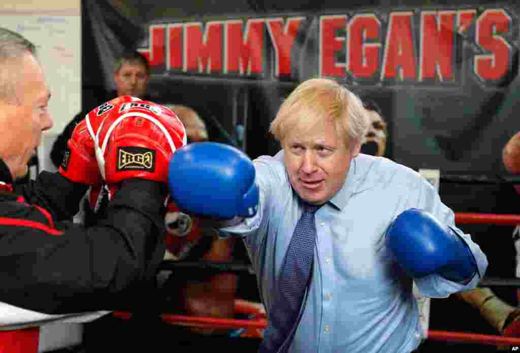 Britain&#39;s Prime Minister Boris Johnson works out with trainer Steve Egan during a stop along his General Election Campaign trail, at Jimmy Egan&#39;s Boxing Academy in Manchester, England.