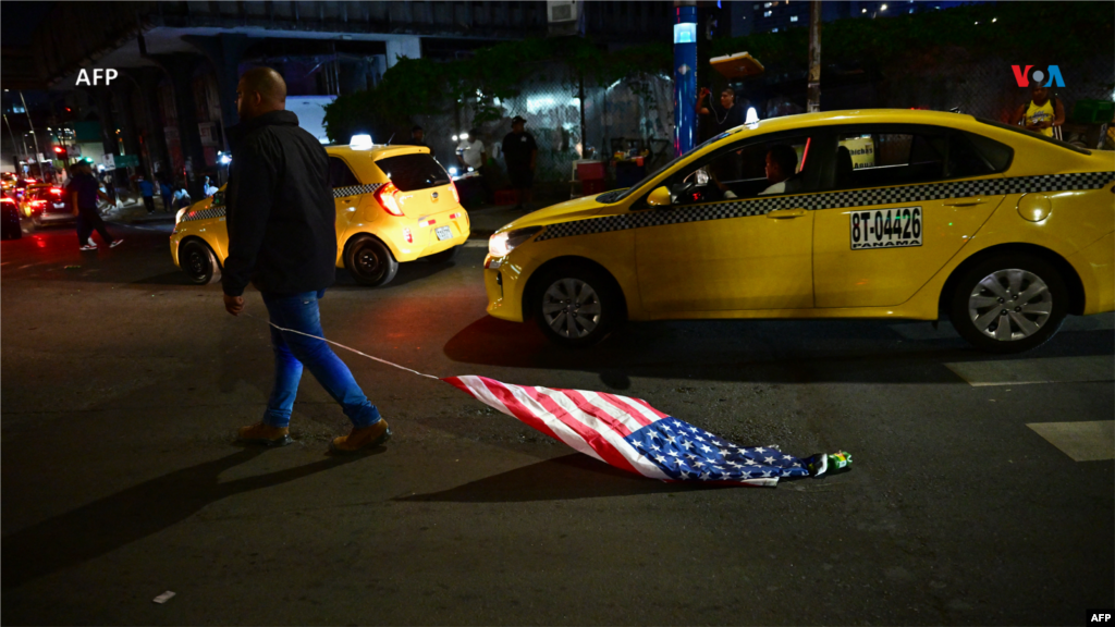 Un manifestante arrastra una bandera estadounidense mientras participa en la protesta en Ciudad de Panamá.