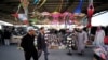 FILE - Visitors walk in front of a stands during weekend flea market in Isa Town, Bahrain, Feb. 10, 2018. In a report published Jan. 14, 2019, a group of Middle East researchers found that areas where residents are exposed to sectarian mixing are less prone to sectarian violence.