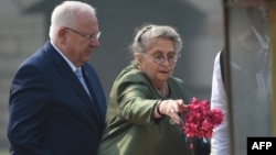 FILE - Israeli President Reuven Rivlin (L) watches as his wife Nechama Rivlin sprinkle rose petals while paying tribute at the Rajghat memorial for Indian independence hero Mahatama Gandhi on his visit to New Delhi, Nov. 15, 2016.